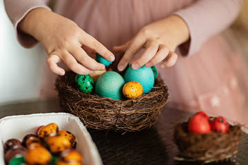 Fototapeta na wymiar Cute little girl holding nest with Easter eggs on white background. Adorable child celebrate Easter holiday