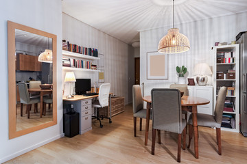 Desk with computer and dining room together in a small apartment.