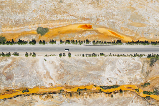 Road in wasteland of Karabash industrial area, aerial top down view. Chemical pollution of land by toxic waste. Ecological disaster in Karabash town, Chelyabinsk Oblast, Ural, Russia
