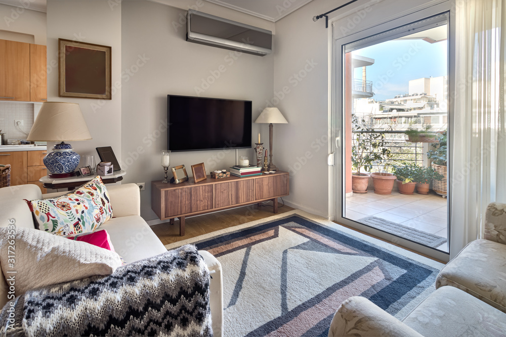 Wall mural perspective view of a small living room with flat tv, cabinet, lamps and sofas.