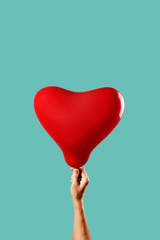 man with a red heart-shaped balloon