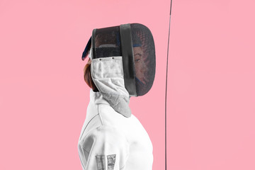 Young female fencer on color background