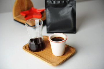 Obraz na płótnie Canvas Stylish served specialty alternative black coffee. Bamboo tray, carafe. Ceramic cup without a handle. Aesthetics coffee