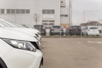 A row of used vehicles parked at a car dealership stock for sales