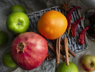 Fruits and red peppers with cinnamon on the basket