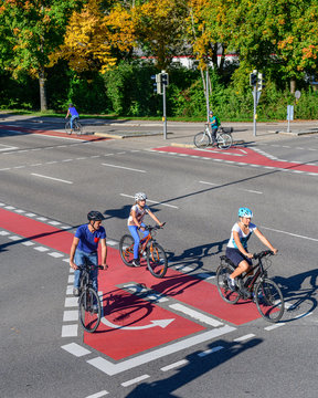 Radfahrer passieren eine Kreuzung auf gut markierter Radwegef&uuml;hrung