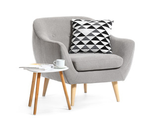 Modern armchair and table on white background