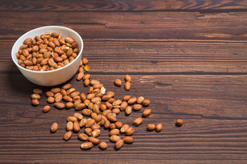 raw peanuts grains . on a wooden background. natural vegetarian vegetable protein . the view from the top.