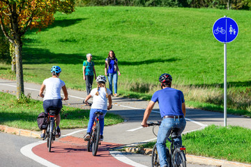 Radfahrer befahren einen Übergang von der Straße auf einen kombinierten Rad- und Fußweg