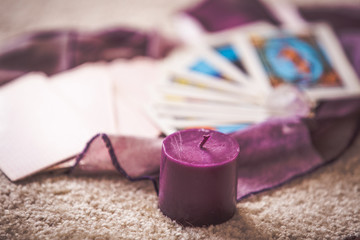 Tarot cards and purple candle esoteric background