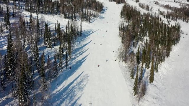 Ski slope. Skiers and snowboarders roll down the track. Aerial photography of a skier descending a wide ski slope