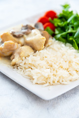 Pieces of chicken fillet cooked in a cream sauce with mushrooms and lemon juice, served with rice.
