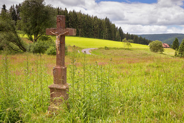Stone crucifix by the road in the Black Forest mountains.