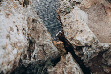 rocky cliff and beautiful sea on sunset rays.