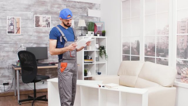Male worker can't figure out the instruction for furniture assembly