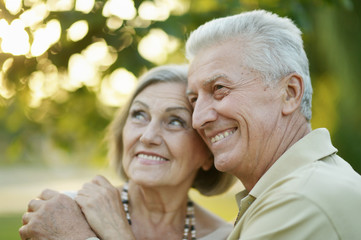 Fototapeta premium Smiling senior couple embracing in autumn park