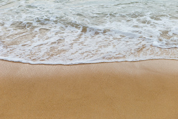 Fototapeta na wymiar White wave on golden sand beach, nature concept background, summer outdoor day light