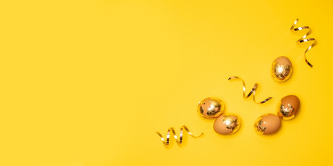 Golden eggs and serpentine on a yellow background