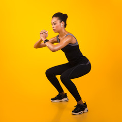 Fototapeta na wymiar Afro Lady Exercising Doing Deep Squat Working Out, Studio Shot