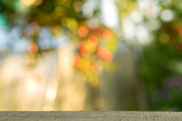 Empty wood table over blurred trees with bokeh background, product display montage