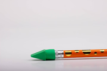 A Green Eraser on a Yellow and Gold Polka Dot Pencil