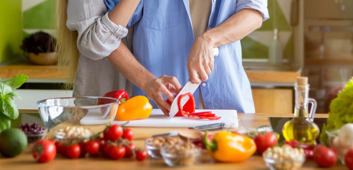 Unrecognizable pair on the kitchen making delicious vegetarian healthy food