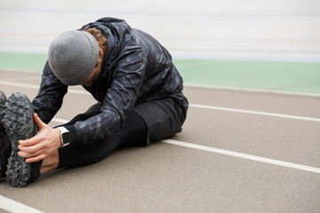 Motivated young fit sportsman working at the stadium