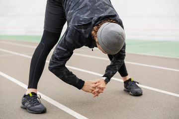 Motivated young fit sportsman working at the stadium