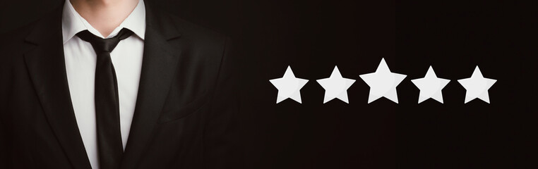 Unrecognizable businessman standing over dark background with five stars icons