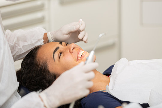 Young woman being seen in a dentist's office. Concept of toothache, wisdom tooth extraction, anesthesia, problems with caries or gums. Oral health care. Dentist day.