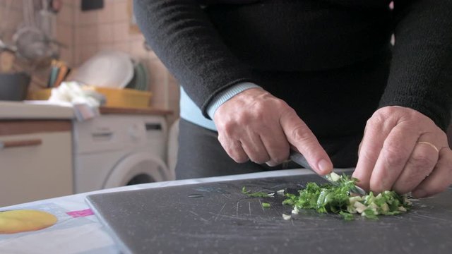 Close up man hand cutting erbs and garlic using knife