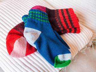 Warm winter wool knitted socks of different sizes and different colors. Waiting for the winter.