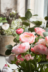 Artificial pink flowers on a background of a white brick wall copy space