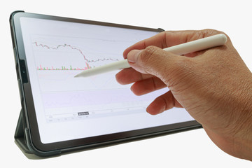The graph shows the results of stock fluctuations on tablets.Hand holding pen check on display