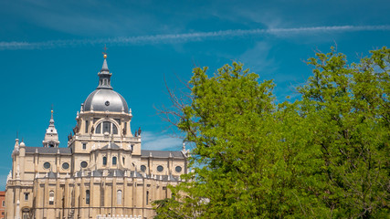 Panoramic view of Almudena cathedral from the famous park Las Vistillas in the downtown Madrid, Spain on a sunny day during the traditional festival in May called San Isidro in the capital of Spain