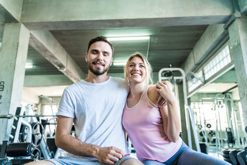 Fototapeta na wymiar Couple men and women happy enjoying exercise in sport gym fitness club