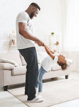 Black Dad Teaching Little Playful Girl Dancing At Home
