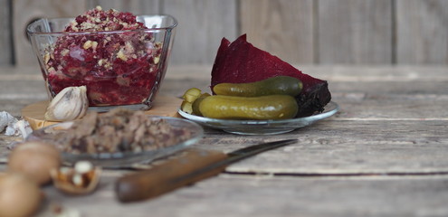 Obraz na płótnie Canvas Salad roast beetroot, liver, nuts and pickles. Home kitchen. Wooden ancient background.