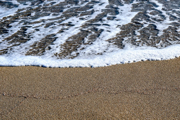 Sea foam on the sand background