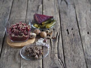 Salad roast beetroot, liver, nuts and pickles. Home kitchen. Wooden ancient background.