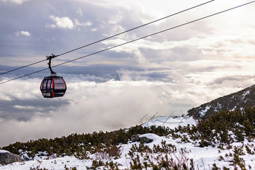 Cableway cabin above the clouds at sunset