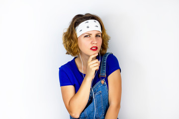 A serious, pensive young girl crossed her arms under her chest. Strict and suspicious woman looking directly at the camera. Lady standing on a white background. The female put her hand to the chin.