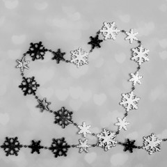 Creative black and white Valentine's day background. Heart of shiny metallic snowflakes in hearts shape. 