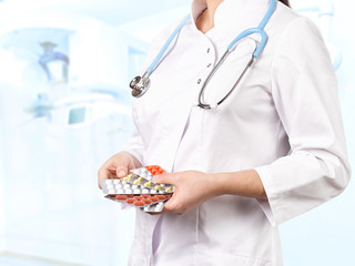 Closeup of the hands of a female doctor with different drugs and pills