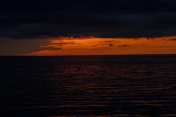 Clear sunset by the sea with dense clouds before dusk