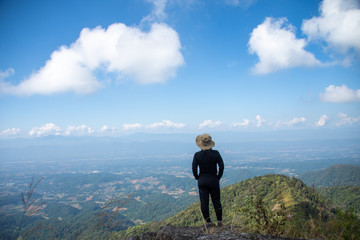 young woman stand on top mountain, view point with blue sky at sunny day. soft focus.