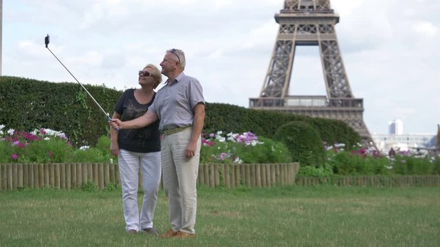 Senior couple taking selfie in front of Eiffel tower in Paris in 4k slow motion 60fps