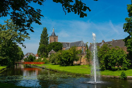 canal,  bridge, city wall, trees and church Grote Kerk in fortified city Vianen. The Netherlands 