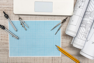 Workplace of engineer. Top view of laptop, notepad, and drawing tools