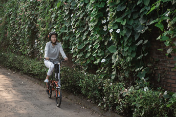 Naklejka premium Asian women wear helmets to ride folding bikes for sports in the morning